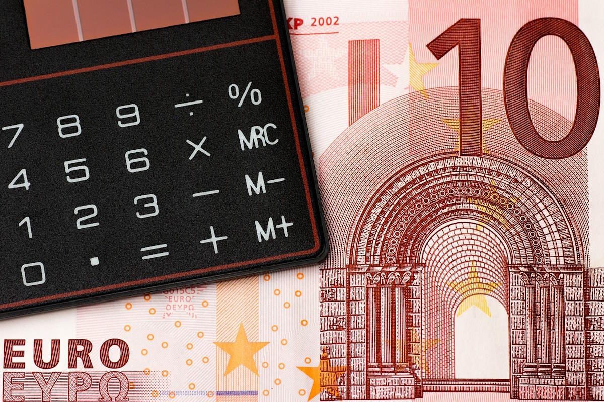 Imagen de un billete de 10 euros y una calculadora como representación del cálculo de un presupuesto